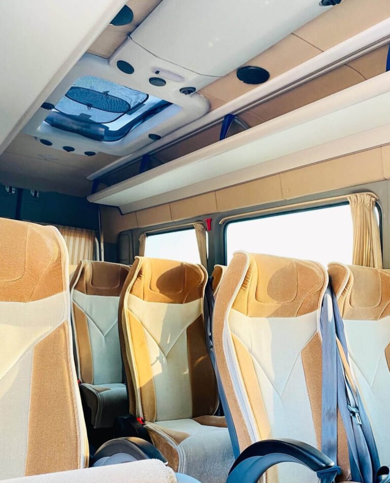 Modern minibus interior with beige seats, overhead storage, and skylight for natural light